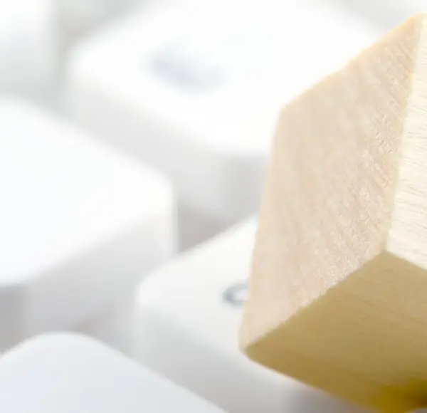 Drewniana kostka z symbolem zamkniętej kłódki, znajdująca się na klawiaturze, symbolizująca certyfikację ISO 27701 Drewniana kostka z symbolem zamkniętej kłódki, znajdująca się na klawiaturze, symbolizująca certyfikację ISO 27701