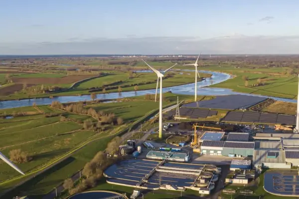 Turbiny wiatrowe w płaskim, nadrzecznym krajobrazie, symbolizujące certyfikację ISO 50001 Turbiny wiatrowe w płaskim, nadrzecznym krajobrazie, symbolizujące certyfikację ISO 50001