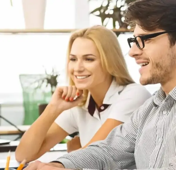 Pracownicy w biurze patrzą na ekran komputera, który przedstawia symbol certyfikacji ISO 9001 Pracownicy w biurze patrzą na ekran komputera, który przedstawia symbol certyfikacji ISO 9001