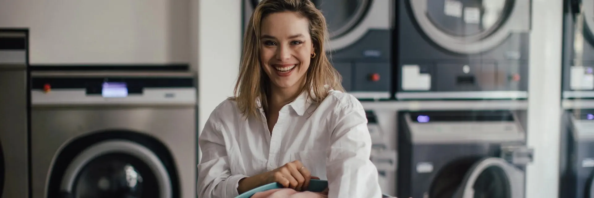 Mloda kobieta robiąca pranie w pralni, symbolizująca certyfikację PN-EN 14065 (RABC) Mloda kobieta robiąca pranie w pralni, symbolizująca certyfikację PN-EN 14065 (RABC)
