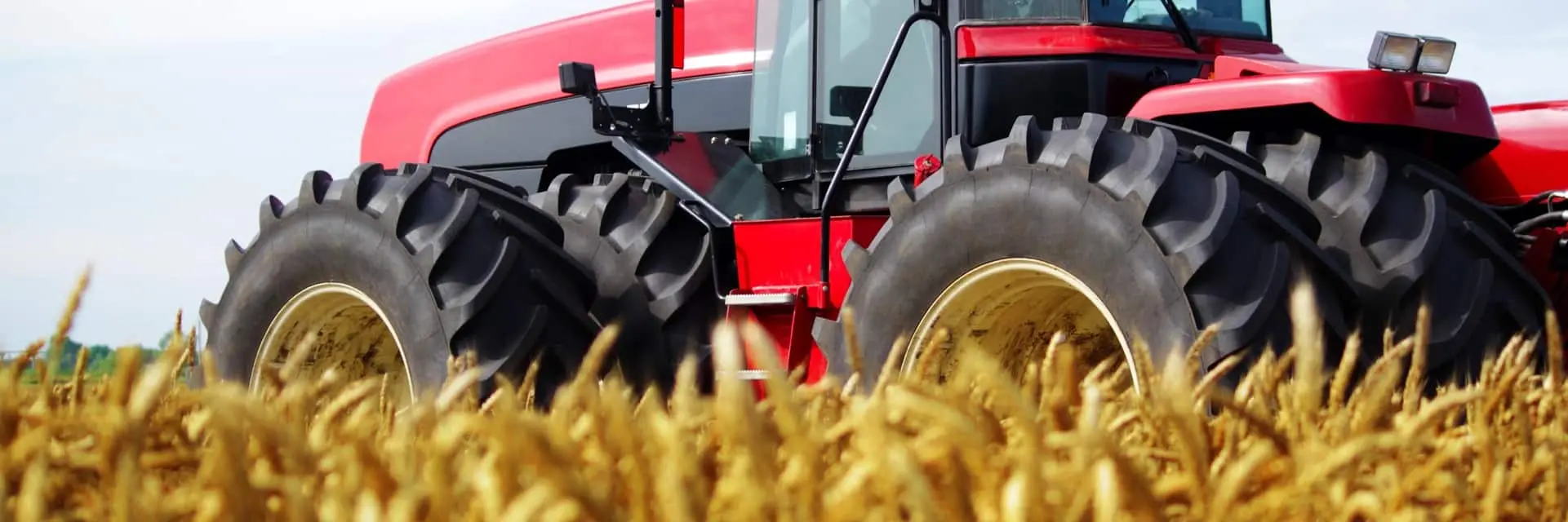 Czerwony traktor pracujący w polu, symbolizujący certyfikację REDcert Czerwony traktor pracujący w polu, symbolizujący certyfikację REDcert