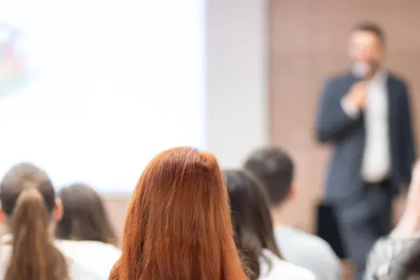 Prelegent przemawiający w sali konferencyjnej przed tłumem ludzi, symbolizujący certyfikację SUS 3.0 Prelegent przemawiający w sali konferencyjnej przed tłumem ludzi, symbolizujący certyfikację SUS 3.0