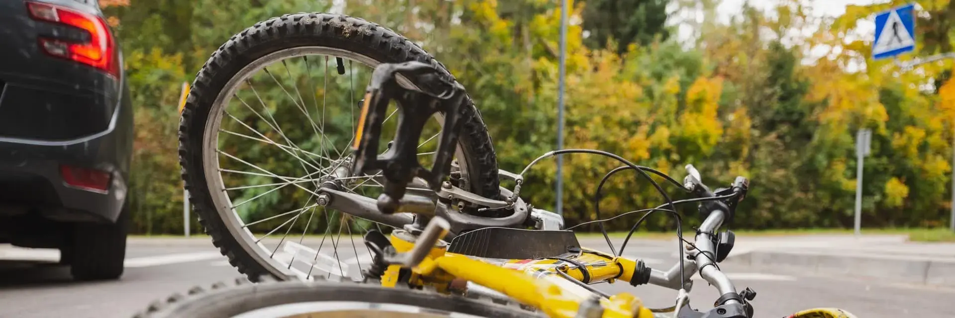 Rower leżący na ulicy obok auta, ilustracja usługi oceny uszkodzeń rowerów elektrycznych