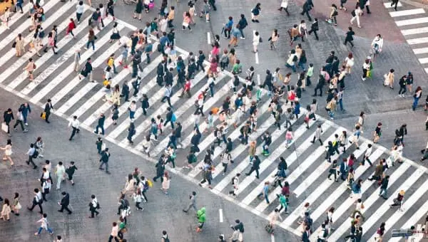 Widok z lotu ptaka na tłum ludzi przechodzących przez skrzyżowanie – pracownicy i społeczeństwo, zrównoważony rozwój i równe szanse w DEKRA.