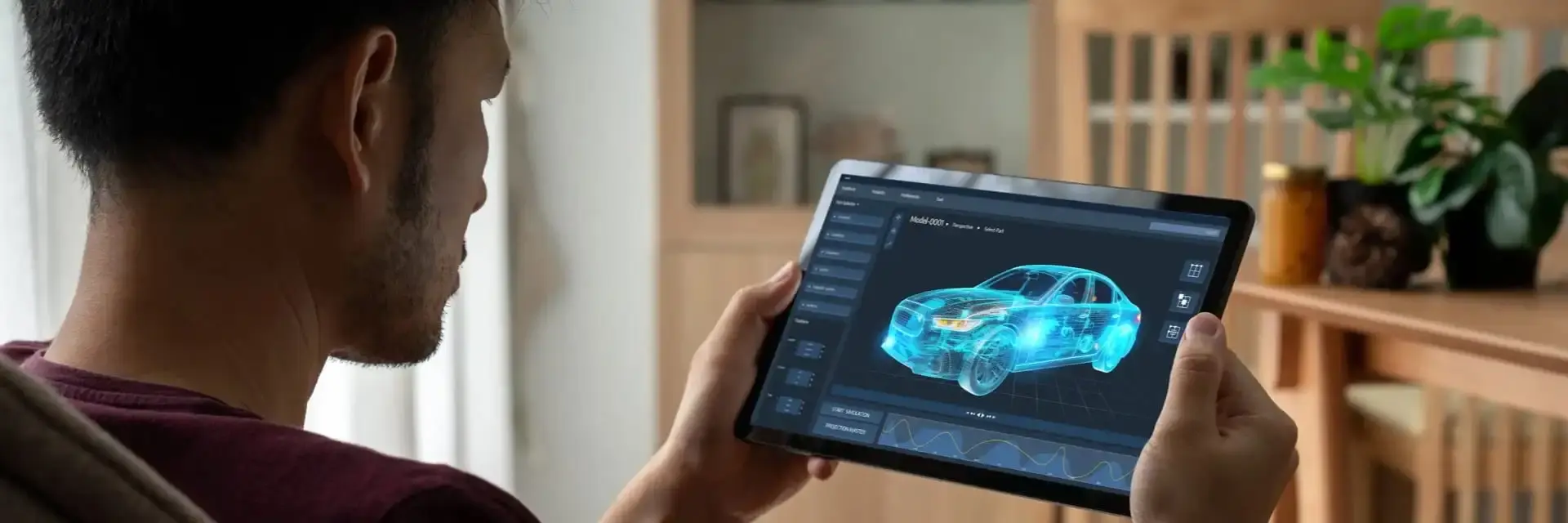 Mężczyzna trzymający tablet z wyświetlonym projektem samochodu elektrycznego