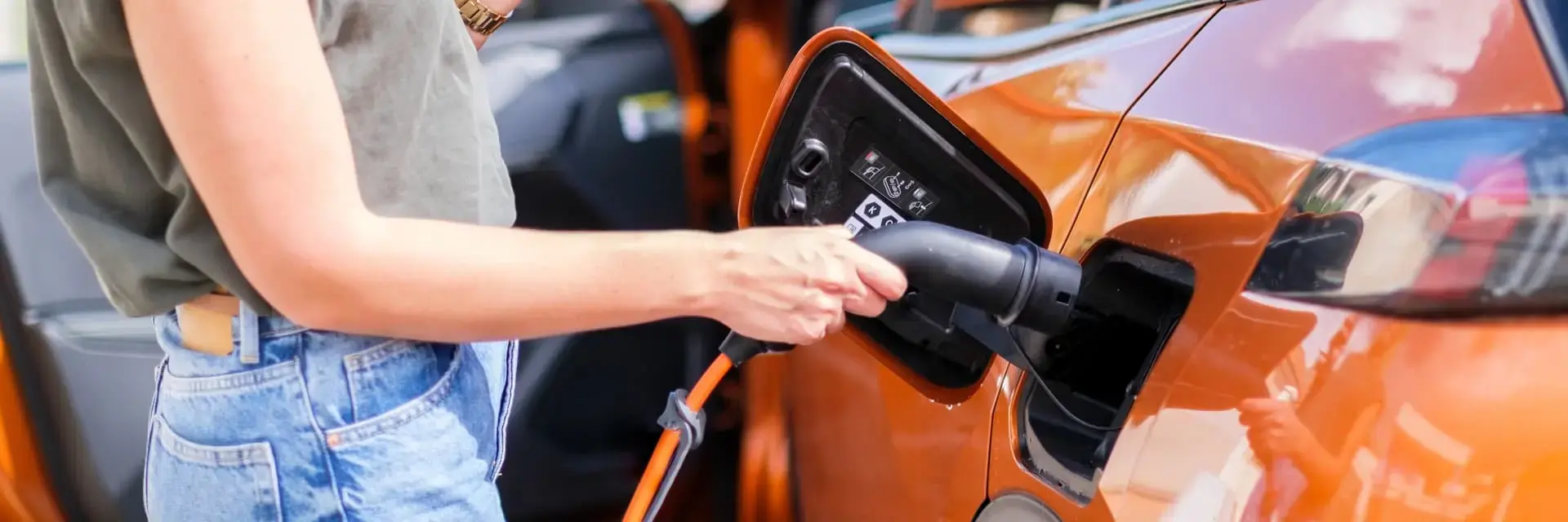 Kobieta ładująca swój samochód elektryczny na stacji ładowania Kobieta ładująca swój samochód elektryczny na stacji ładowania