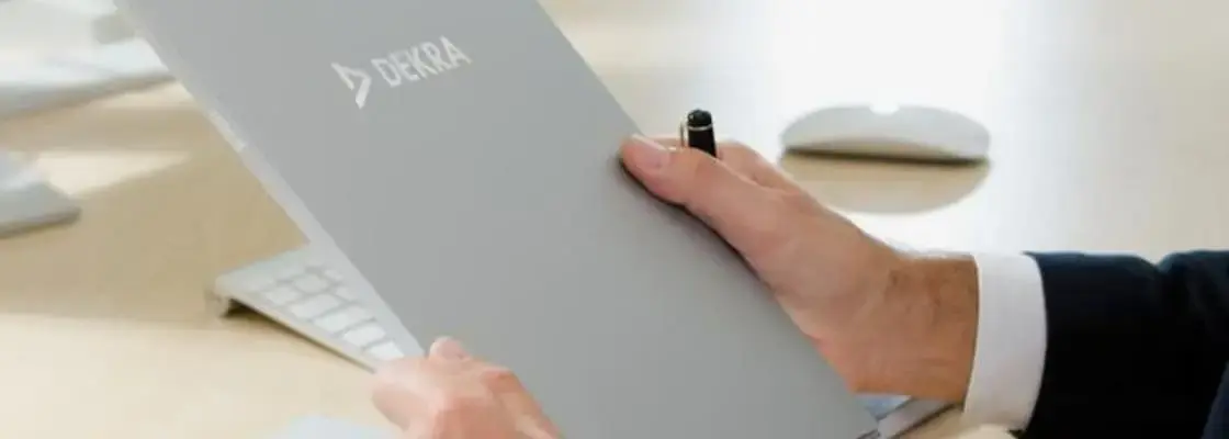 Osoba trzymająca teczkę DEKRA. Wykaz aktualnych certyfikatów wydanych przez DEKRA Certification.