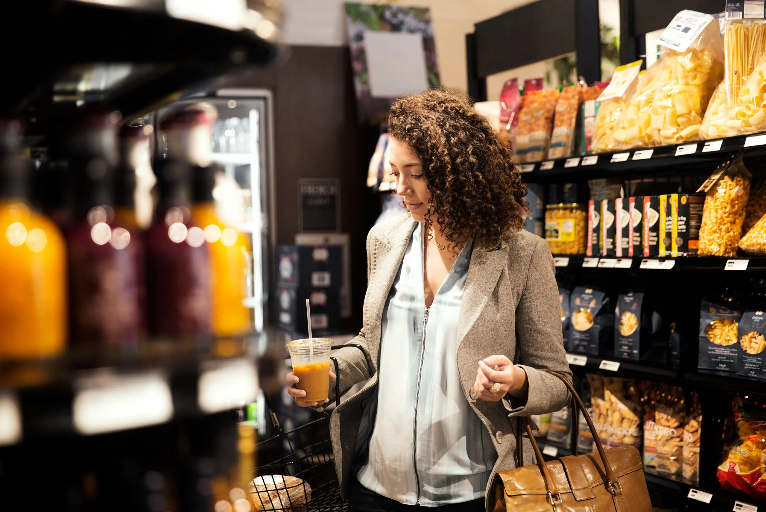 Frau mit Orangensaft in der Hand steht in Supermarkt