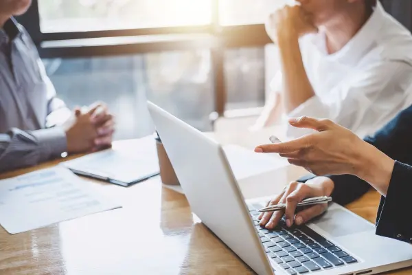 Personen sitzen vor Laptop 