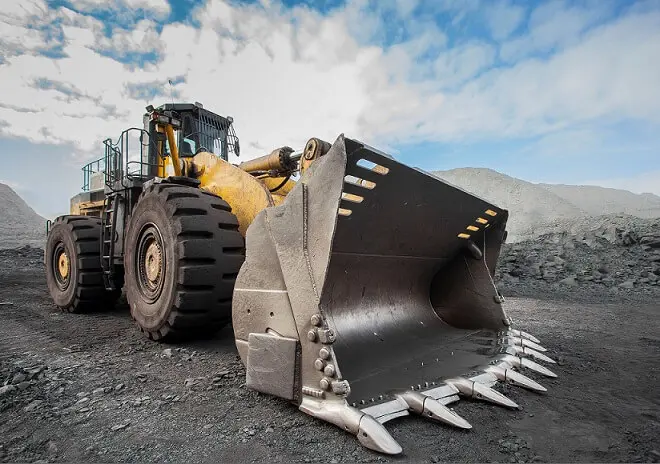En stor traktor sedd snett framifrån med skopan i fokus. En stor traktor sedd snett framifrån med skopan i fokus.