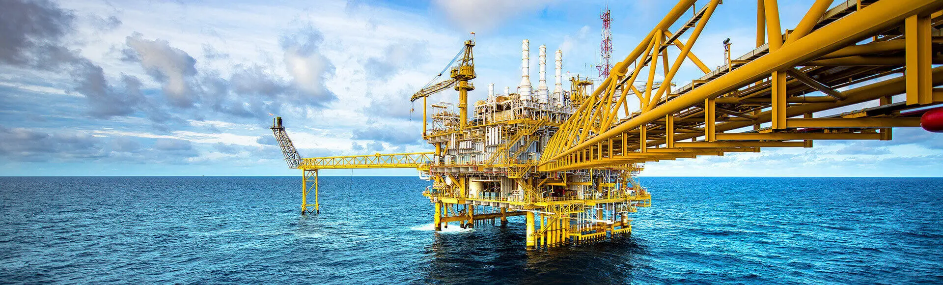 A big yellow oil rig out at sea.