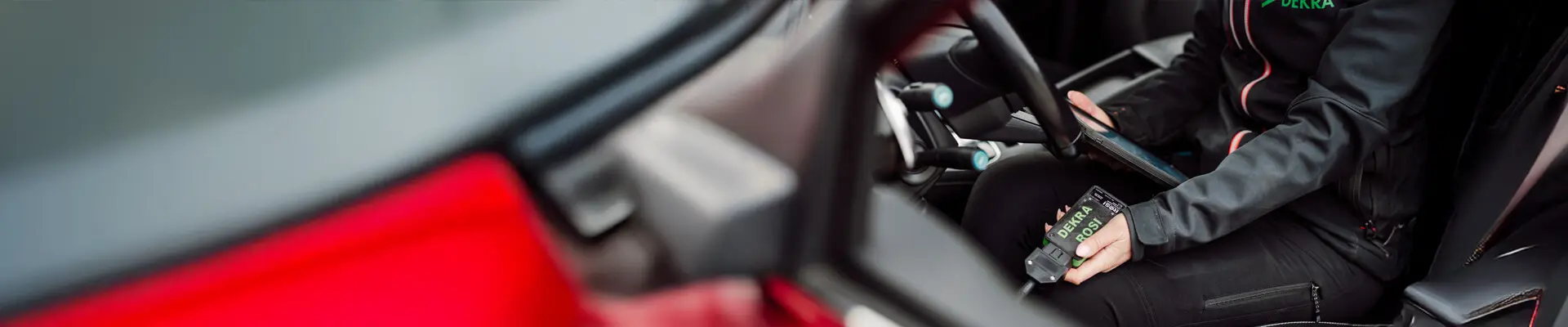 Picture taken through the driver's side window into a car where a receipt is sitting in black clothes and holding a can.