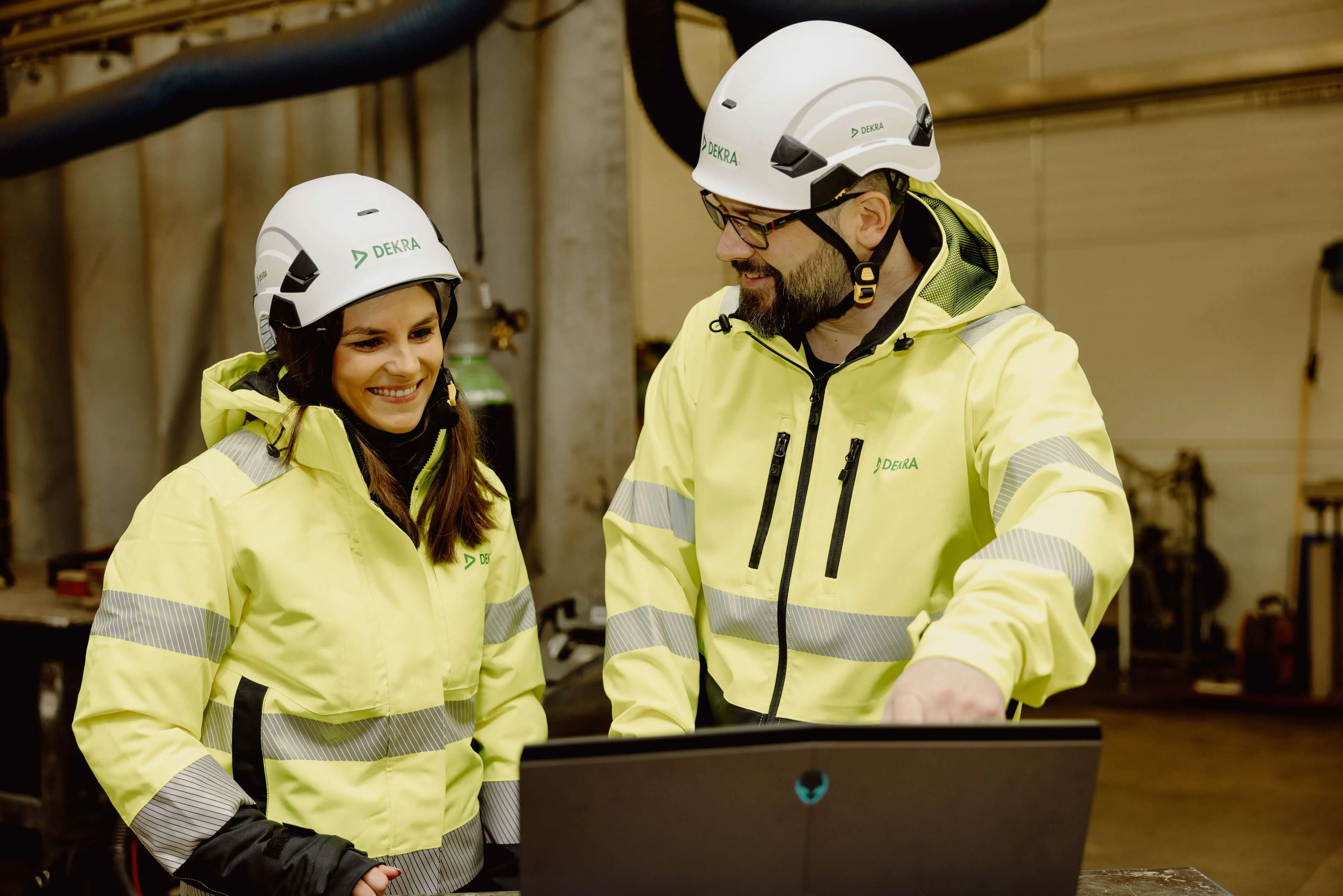  Two persons in yellow jackets and white helmets