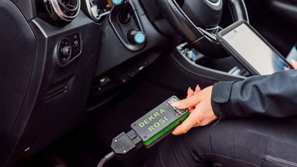 Bild som visar en hand hållandes i en dongel för DEKRA:s batteritest Readout-report 