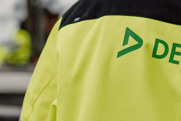 En man i hjälm och vit hjälm, förberedd för säkerhet, exemplifierar professionalism i en byggmiljö. 