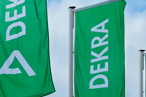 Three green flags with DEKRA written on them, sky as background. Three green flags with DEKRA written on them, sky as background.