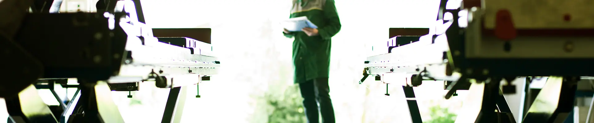 Besiktningsman skriver anteckningar på papper medan han står framför en saxlyft. Besiktningsman skriver anteckningar på papper medan han står framför en saxlyft.