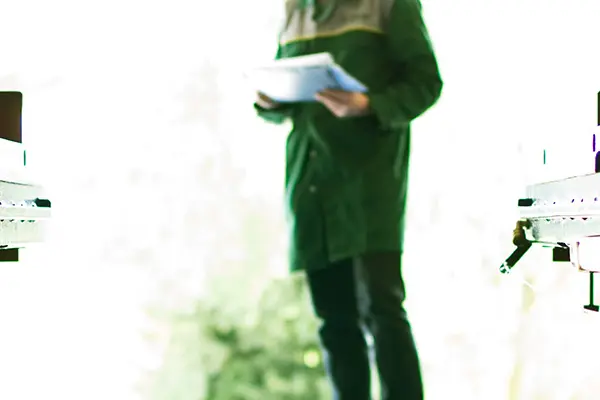 Inspector writing notes on paper while standing in front of a scissor lift.