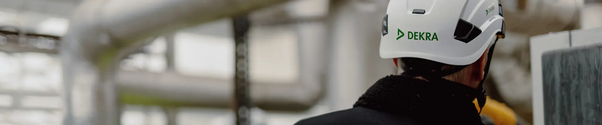  En man i hjälm och vit hjälm, förberedd för säkerhet, exemplifierar professionalism i en byggmiljö. 