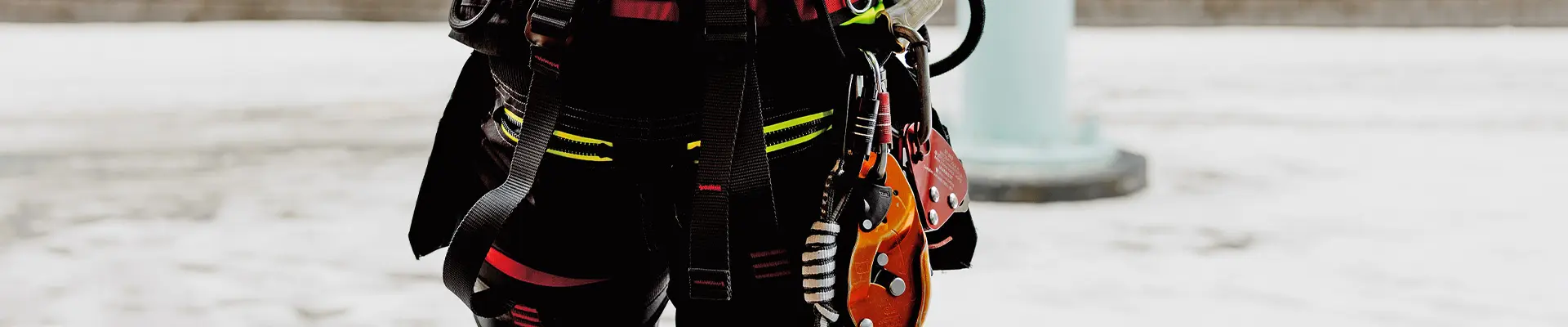 A person wearing a harness and hooks of various types intended for safe climbing.