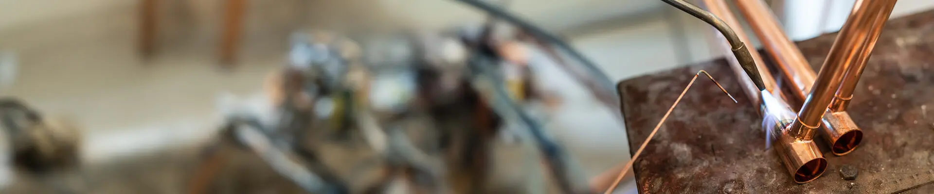 Close-up of copper pipes being welded.