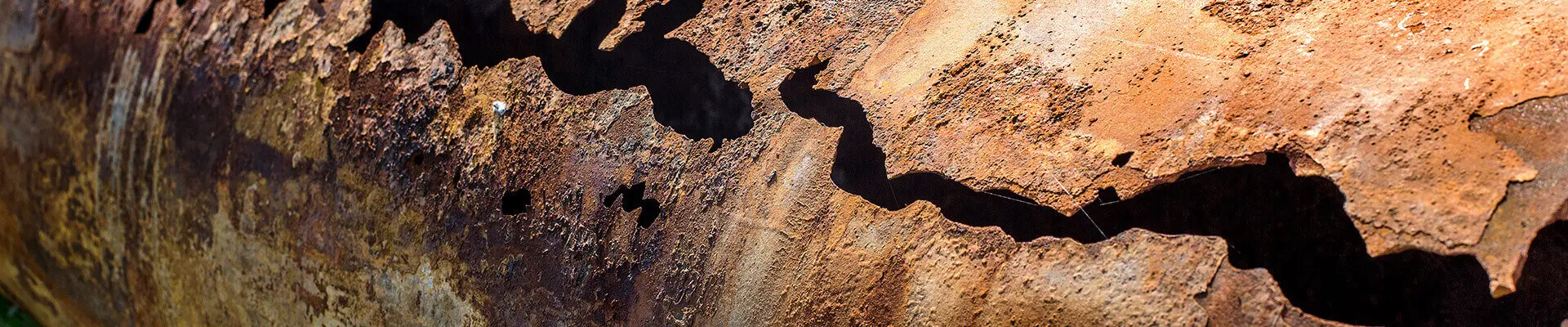  En närbild av en rostig metallbit som visar dess strukturerade yta och väderbitna utseende.