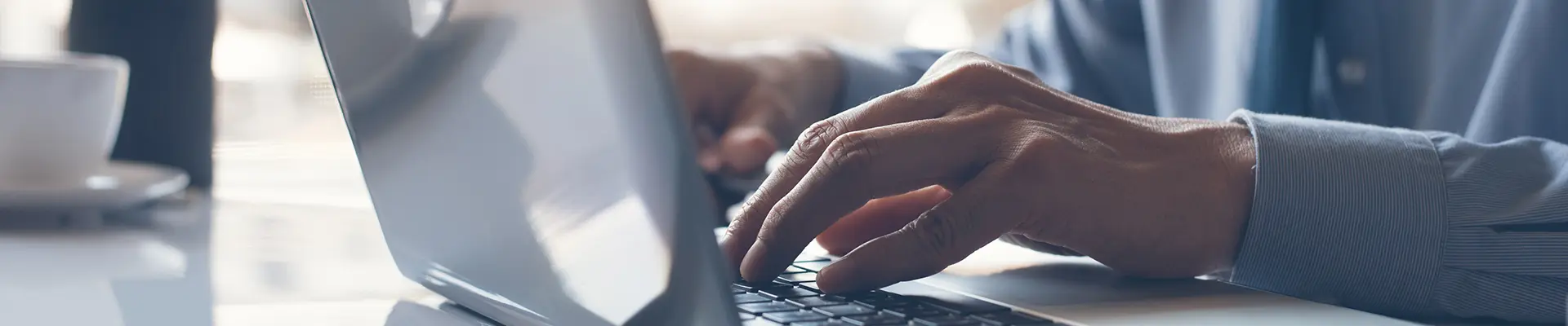 A person's hands typing on a laptop.