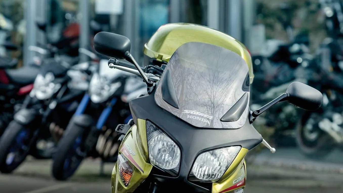 Motorcykel som står farmför en rad med andra motorcyklar utanför en återförsäljare. Motorcykel som står farmför en rad med andra motorcyklar utanför en återförsäljare.
