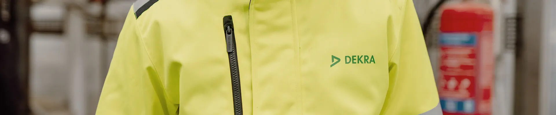 A man in a white hard hat and reflective work clothes, prepared for safety, exemplifying professionalism in a construction environment. 