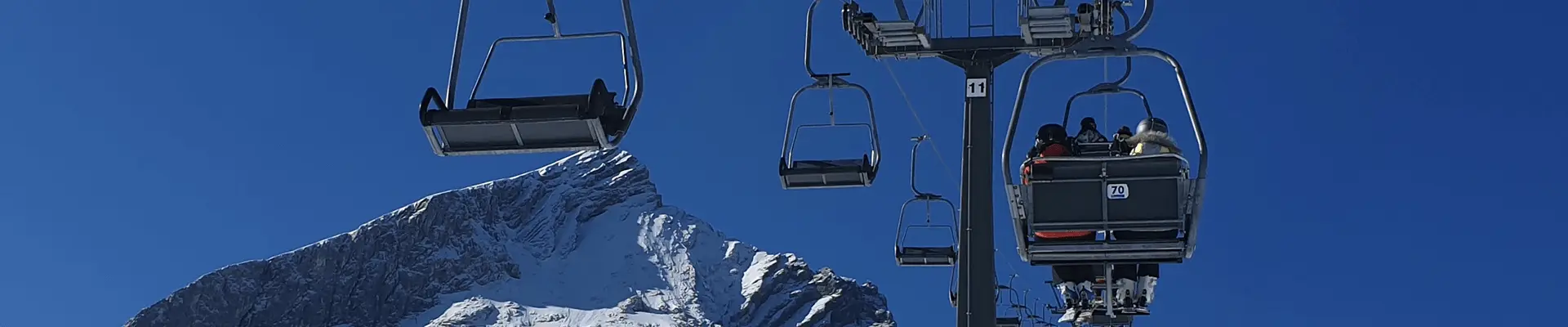A ski lift that is a chair lift with the sky as a background. A ski lift that is a chair lift with the sky as a background.