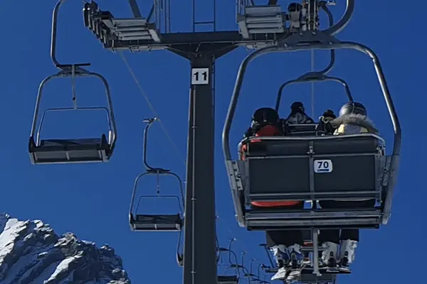 En skidlift som är en sittlift med himmel som bakgrund.