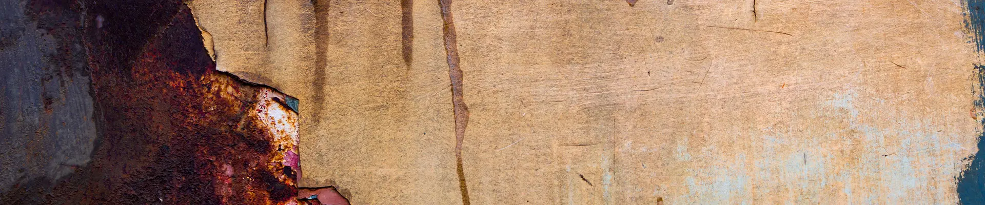 Närbild av en väderbiten, rostig metallyta. Bilden visar en blandning av rostfläckar och flagnande färg, avslöjar olika strukturerade lager och nyanser av brunt, orange och blått. Närbild av en väderbiten, rostig metallyta. Bilden visar en blandning av rostfläckar och flagnande färg, avslöjar olika strukturerade lager och nyanser av brunt, orange och blått.