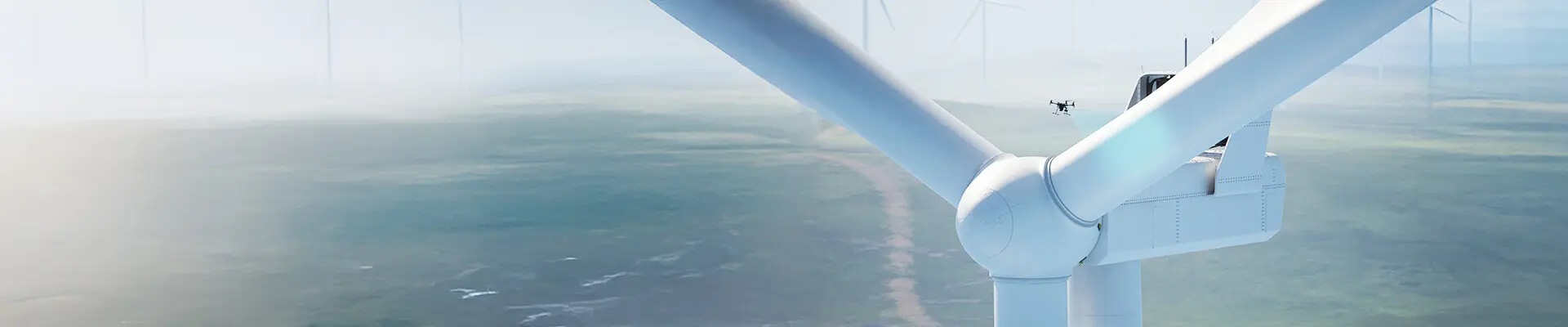 A wind turbine with a drone in the background.