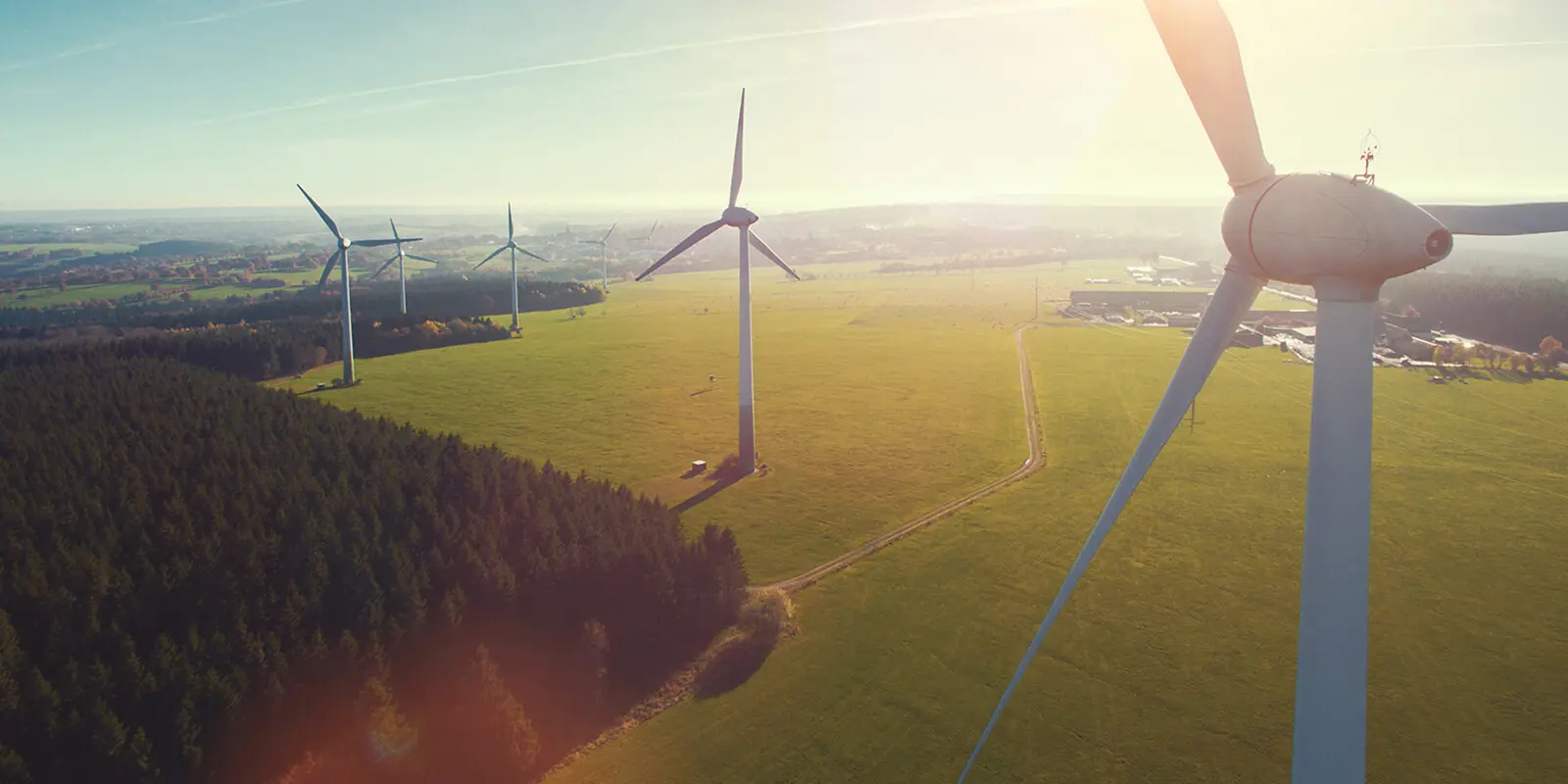 A wind turbine with several wind turbines in the background on large fields.