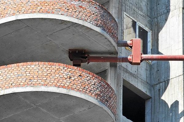 A property with balconies built in concrete and scaffolding outside the facade.