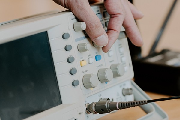 A person sits at a desk and uses a machine for calculation and simulation by turning various components on the machine.