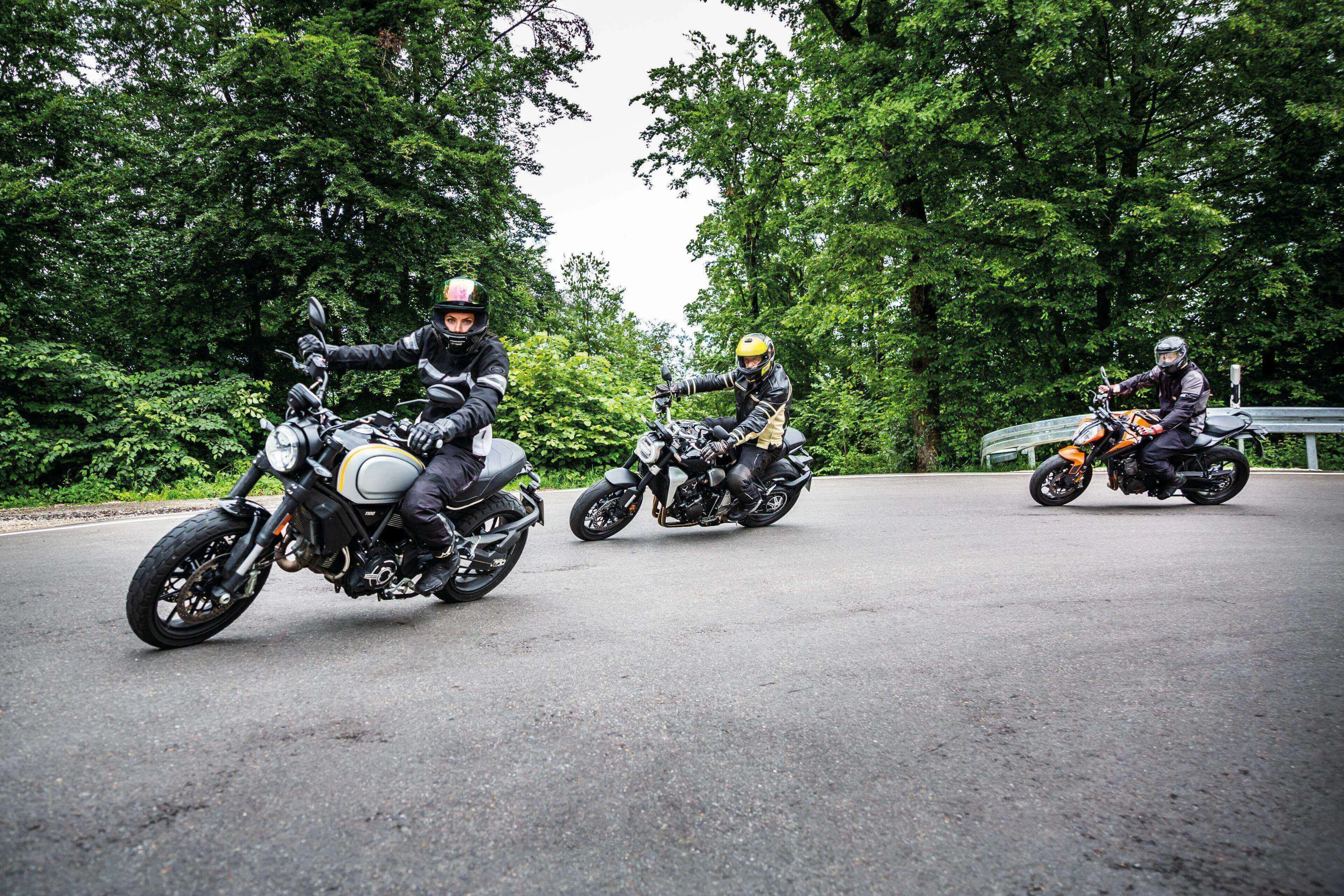 Lien vers la page Contrôle technique moto Trois motards en tenue de protection prennent un virage